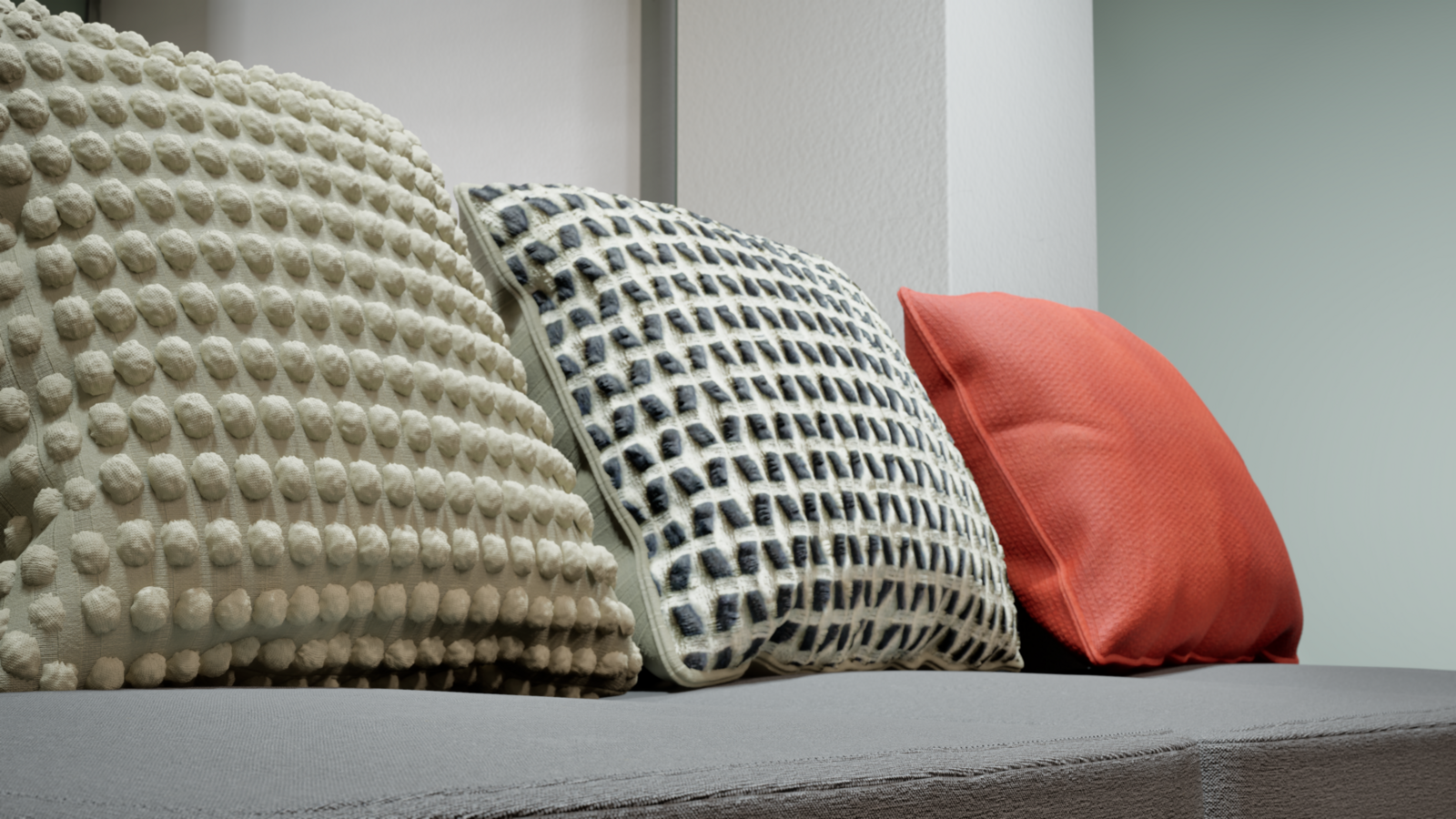  Close-up detail of decorative cushions on a grey sofa, including textured and colorful pillows